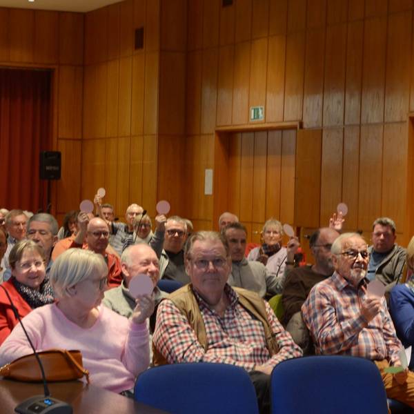 Ein Blick in den Saal mit Frauen und Männern, die in Reihen sitzen.