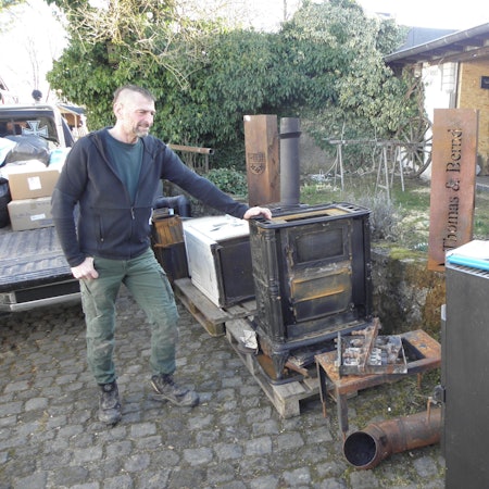Thomas Claßen steht in Marmagen an zahlreichen gespendeten Öfen, die er und sein Team in die Ukraine bringen.