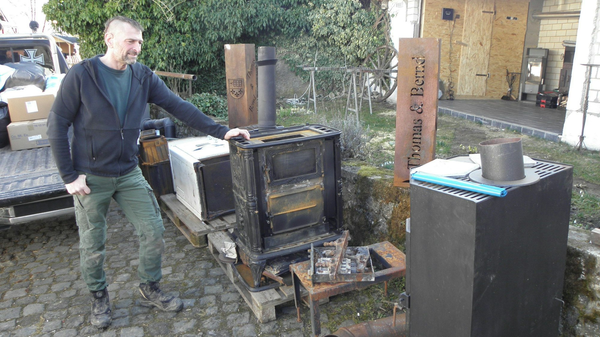 Thomas Claßen steht in Marmagen an zahlreichen gespendeten Öfen, die er und sein Team in die Ukraine bringen.