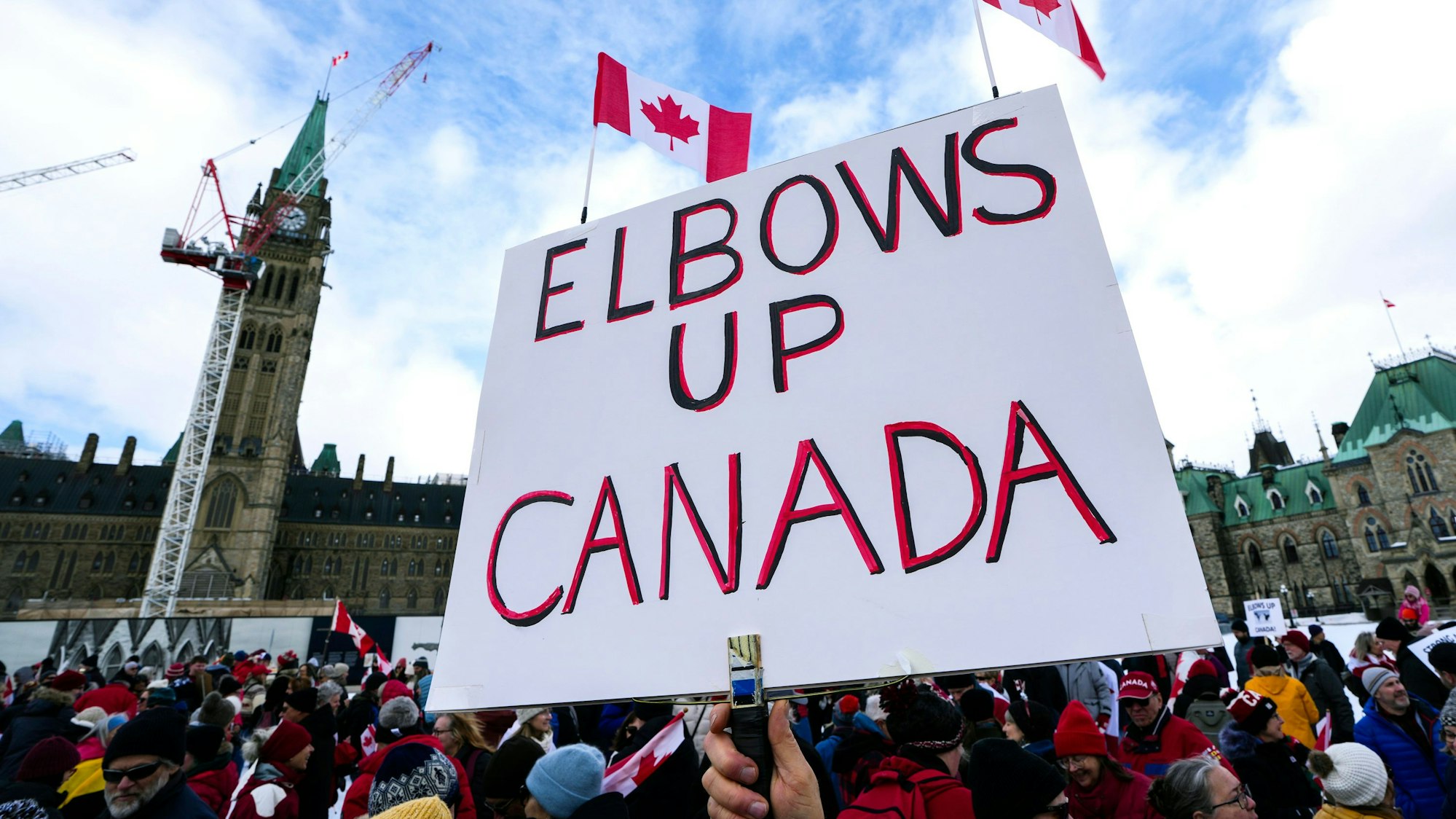 Ein Teilnehmer hält ein „Elbows Up Canada“-Schild („Ellenbogen hoch Kanada“) während einer Kundgebung nach Drohungen von US-Präsident Donald Trump gegen die kanadische Souveränität. (Archivbild)