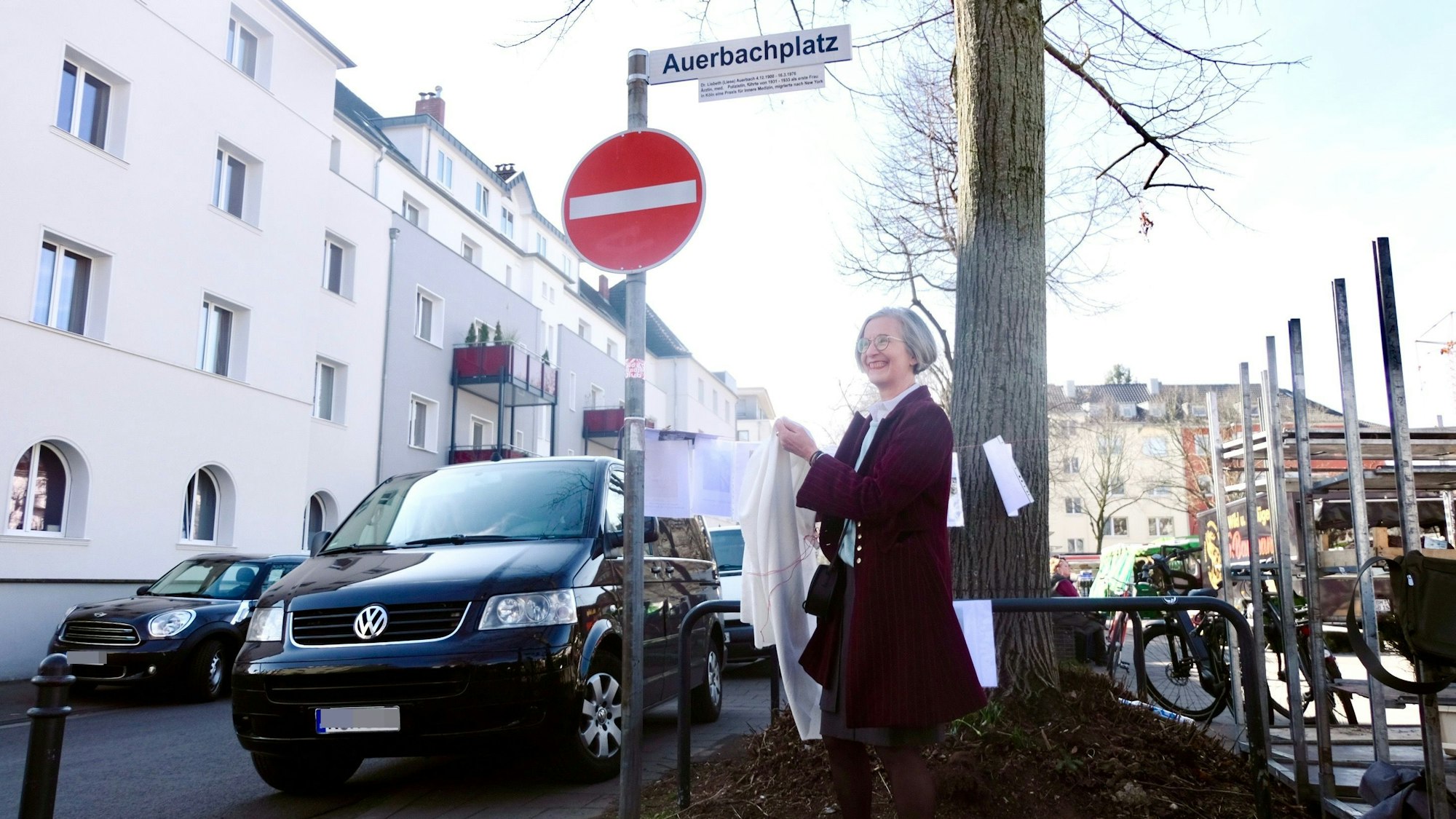 Eine Frau enthüllt eines der neuen Erklärschilder am Auerbachplatz.