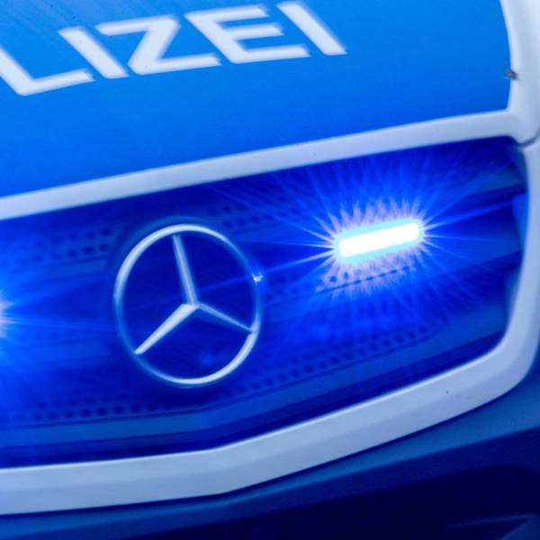 Ein Einsatzfahrzeug der Polizei fährt mit Blaulicht durch eine Stadt.