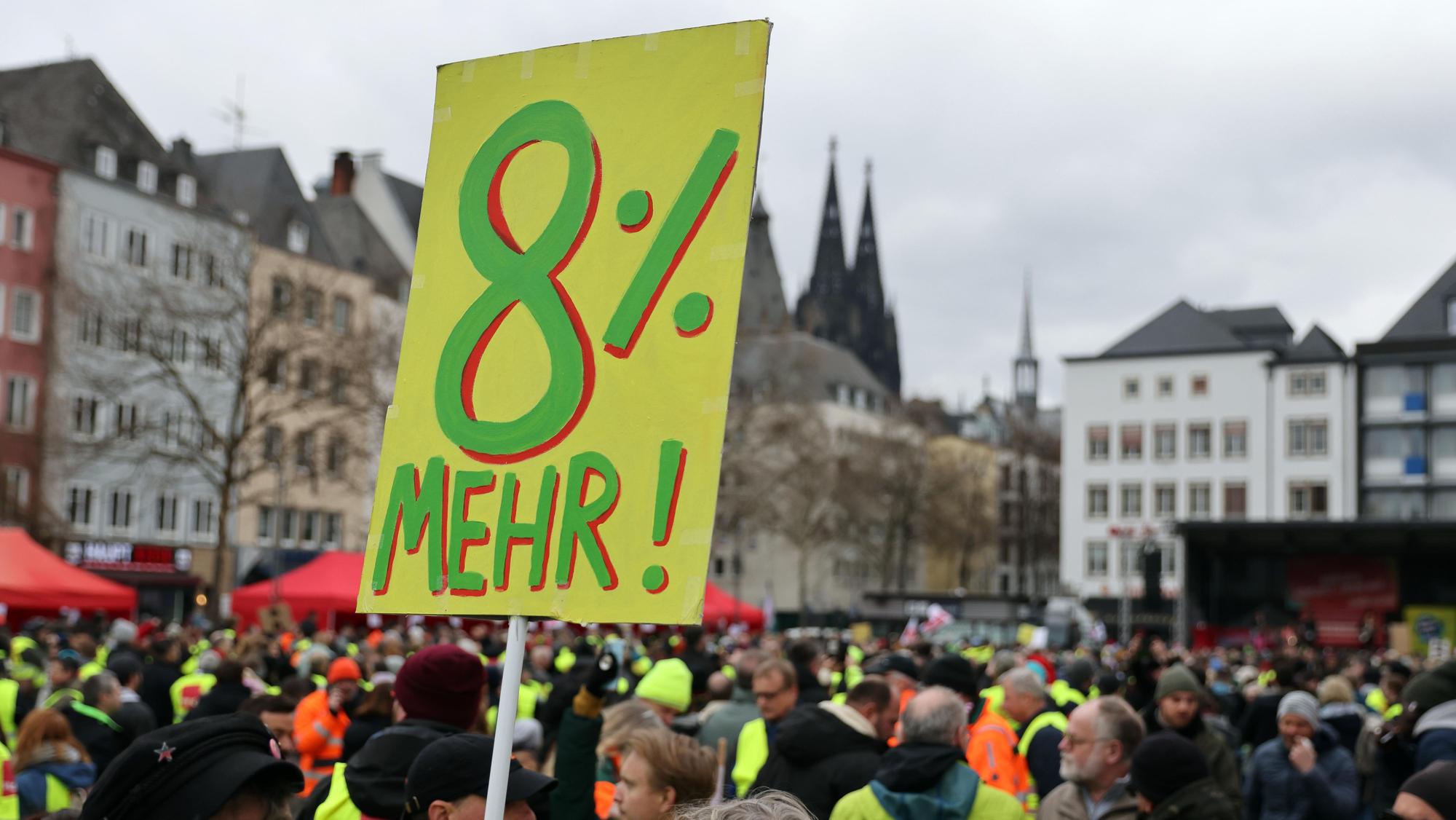Auf einem Transparent werden acht Prozent mehr Lohn gefordert.