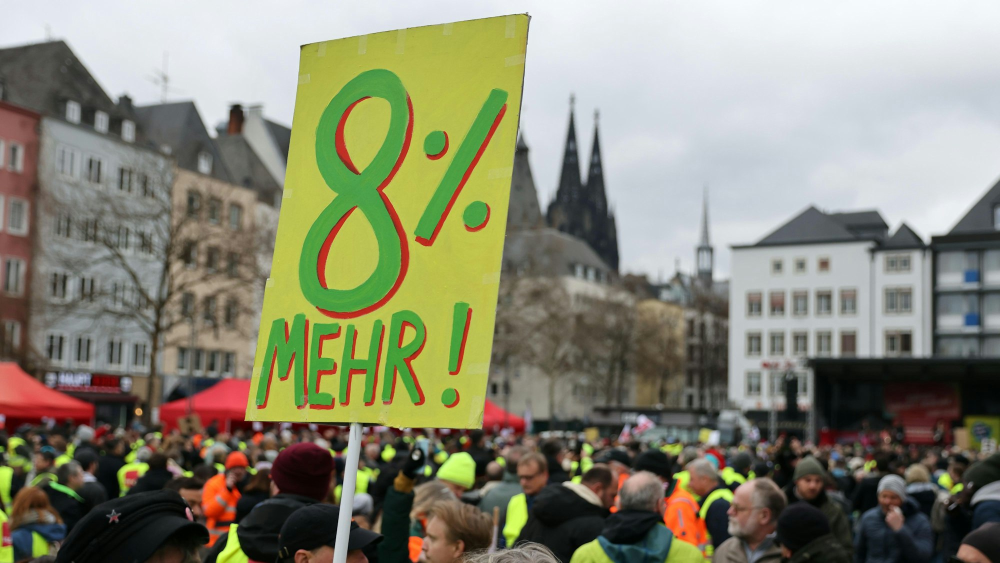 Auf einem Transparent werden acht Prozent mehr Lohn gefordert.