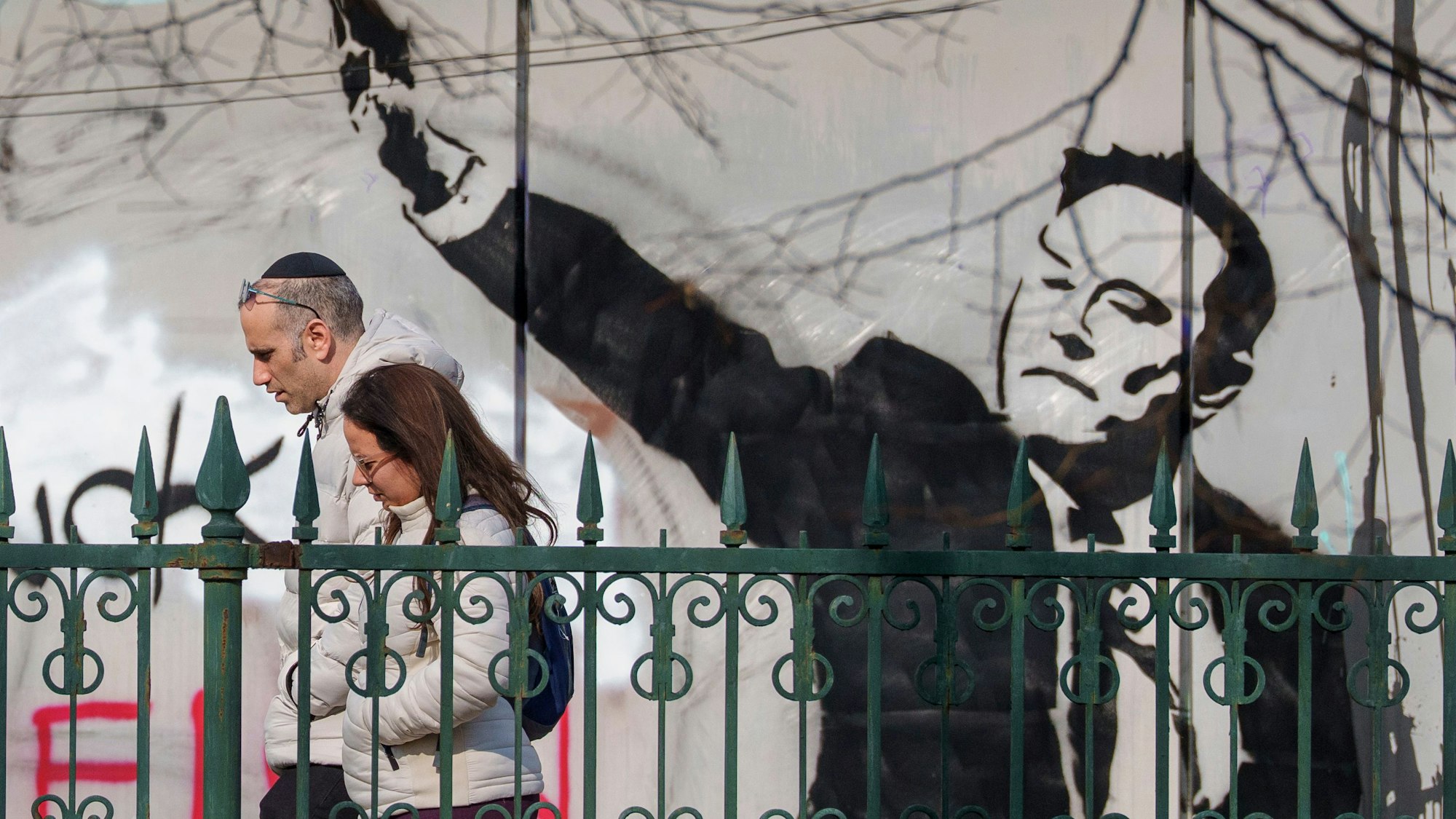 Menschen gehen in Bukarest an einem Wandgemälde vorbei, das Tech-Milliardär Elon Musk beim Hitlergruß zeigt. (Archivbild)