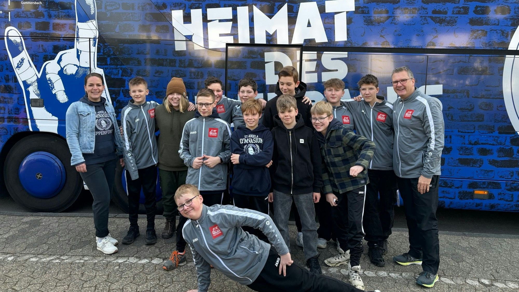 Mannschaftsfoto vor dem Bus mit dem Schriftzug "Heimat des Handballs"