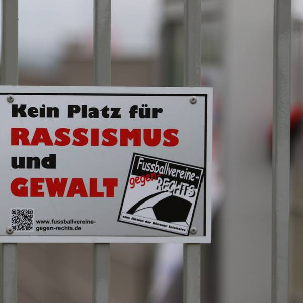 Auf einem Schild an einem Sportplatzzaun steht „Kein Platz für Rassismus und Gewalt“.