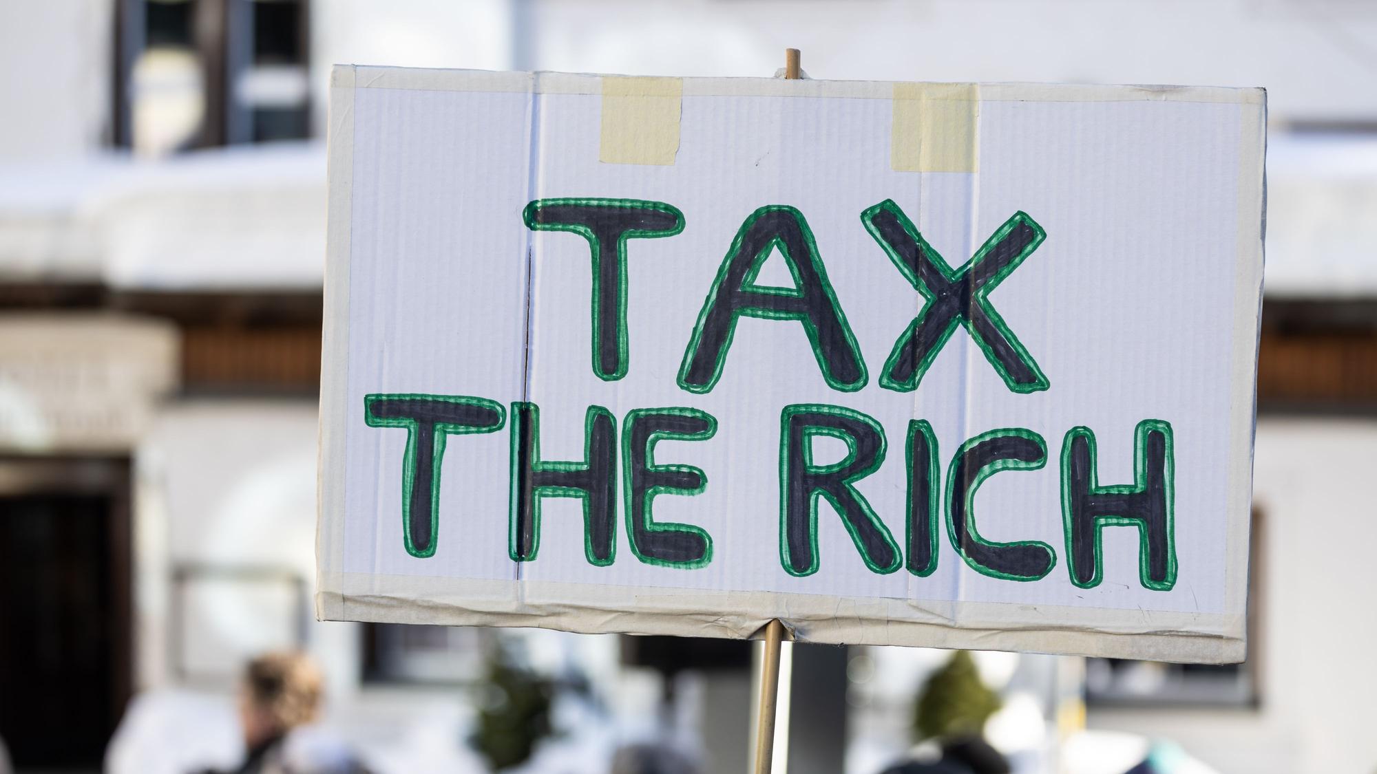 Auf einem Schild steht «Tax the rich». Hunderte Menschen demonstrierten für Klimagerechtigkeit unter dem Titel «Strike WEF» in Davos. Die Demonstranten kritisieren dabei das World Economic Forum (WEF) in seiner Rolle und werfen den teilnehmenden Konzernen vor, dass diese aktuelle Krisen anfeuern und davon profitieren.