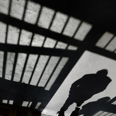 Ein Mann geht nach einem Rundgang durch die Justizvollzugsanstalt in den Außenbereich.