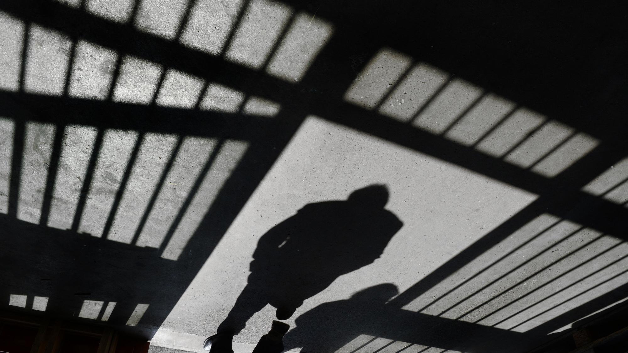 Ein Mann geht nach einem Rundgang durch die Justizvollzugsanstalt in den Außenbereich.