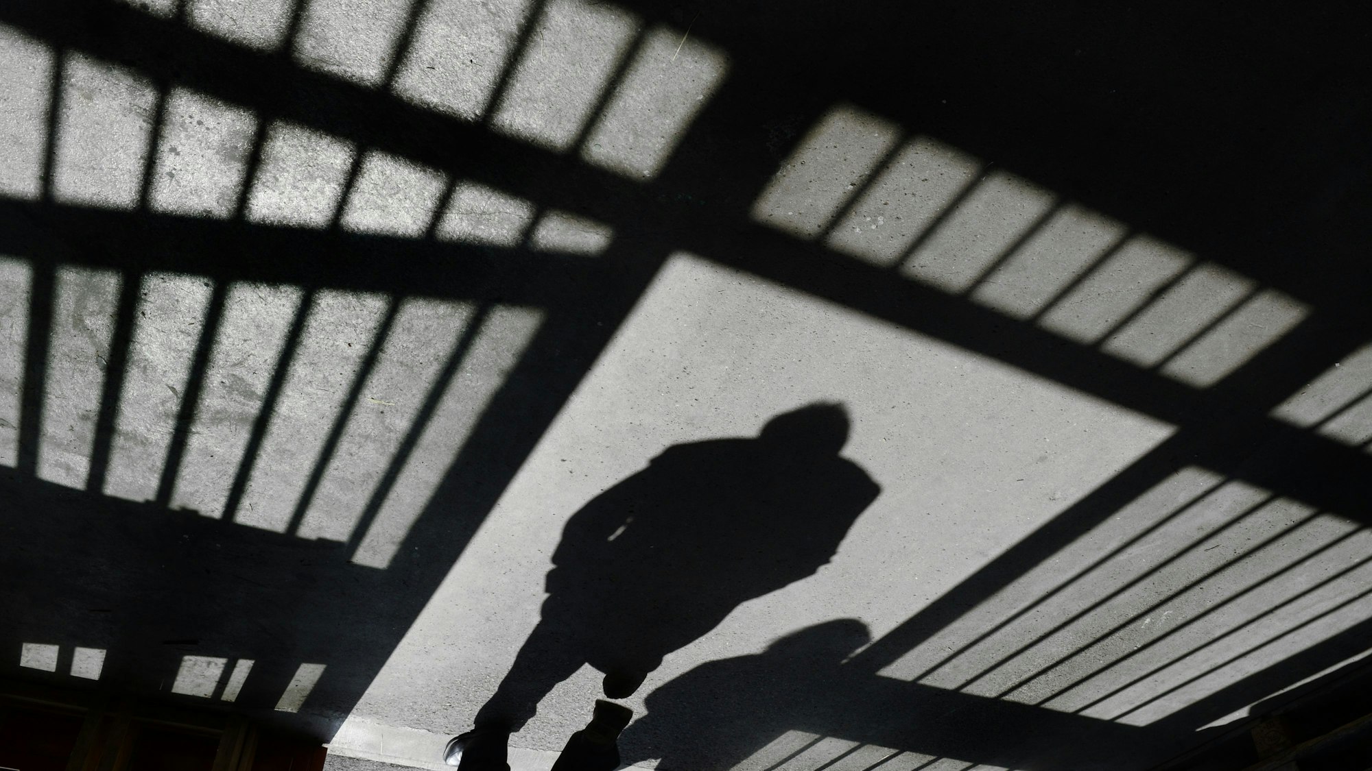 Ein Mann geht nach einem Rundgang durch die Justizvollzugsanstalt in den Außenbereich.