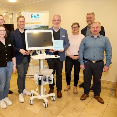 Drei Frauen und fünf Männer stehen um einen fahrbaren Computer, der im Altenheim in Gemünd im Bereich der Telemedizin eingesetzt wird.