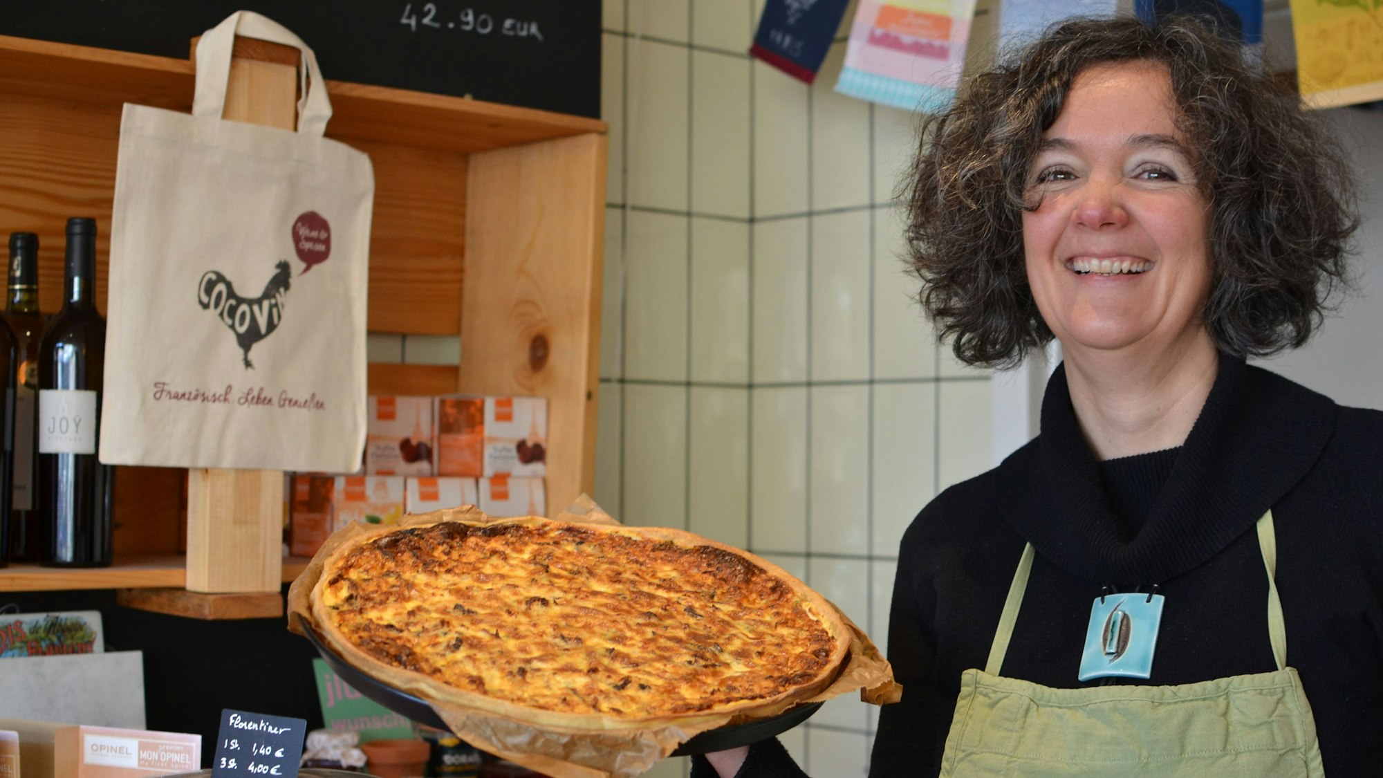 Das Foto zeigt die Unternehmensgründerin mit einer Quiche in ihrem Laden.