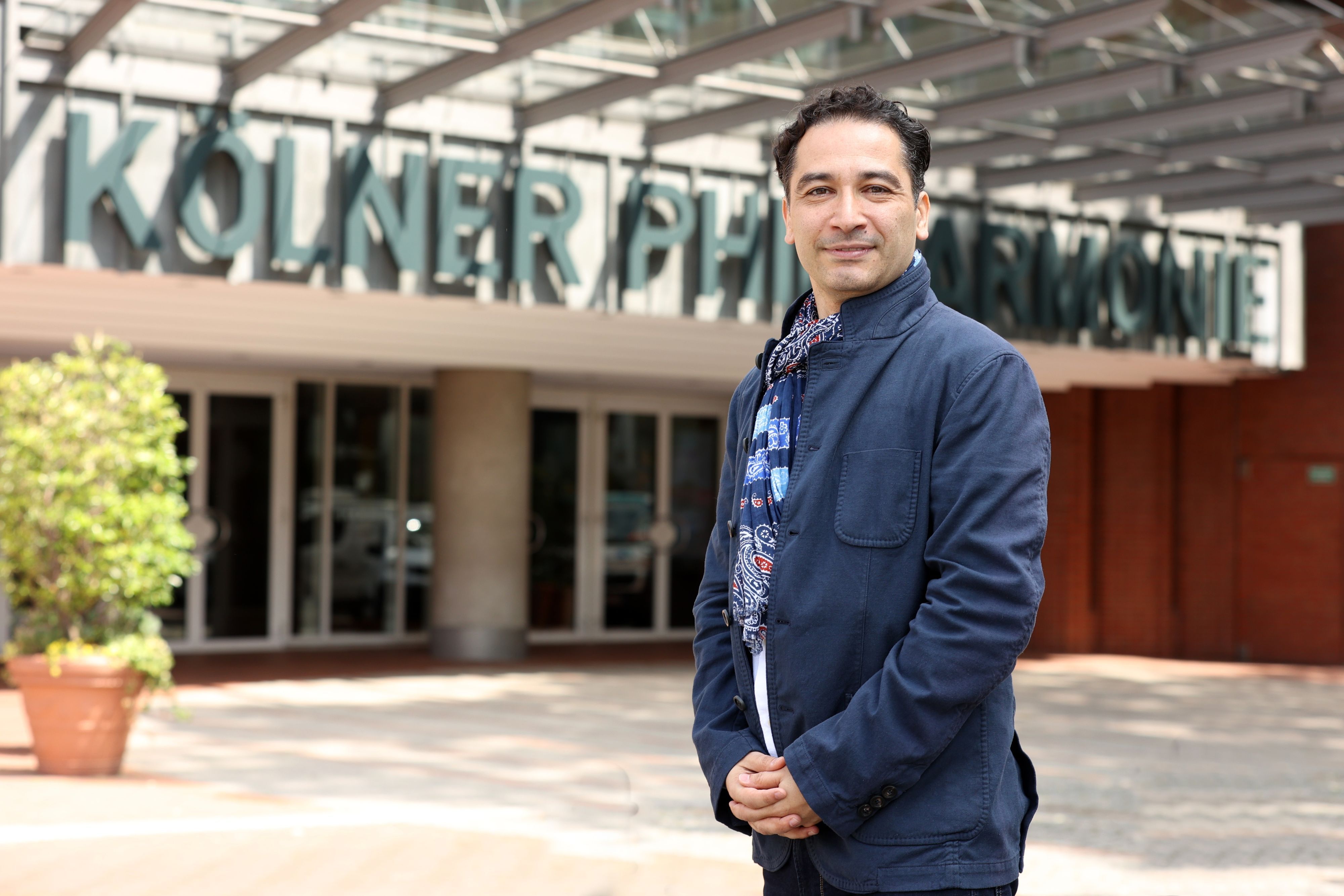 Andrés Orozco-Estrada steht vor dem Eingang zur Philharmonie.