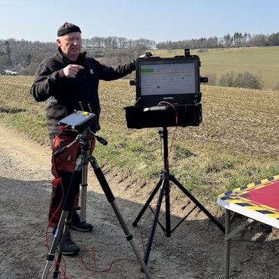 Ein Mann startet auf einem Feld eine Drohne.