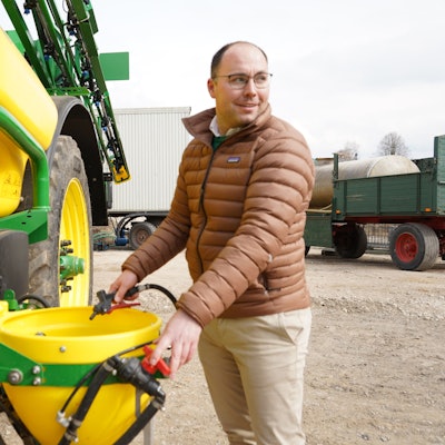Das Foto zeigt Eric Lothmann an einer Pflanzenschutzmittelspritze.