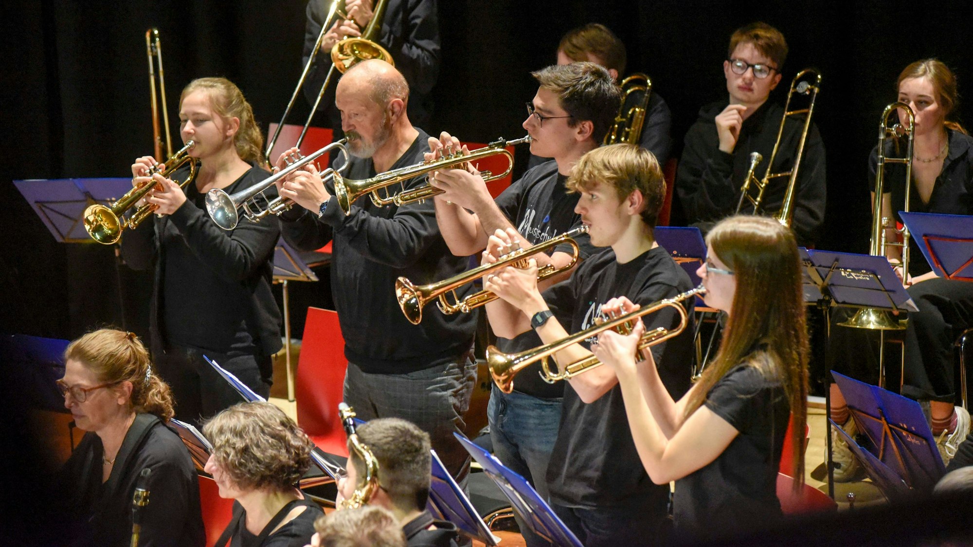 Zu sehen sind eine mehrere Reihen von Blechbläsern beim Spielen.