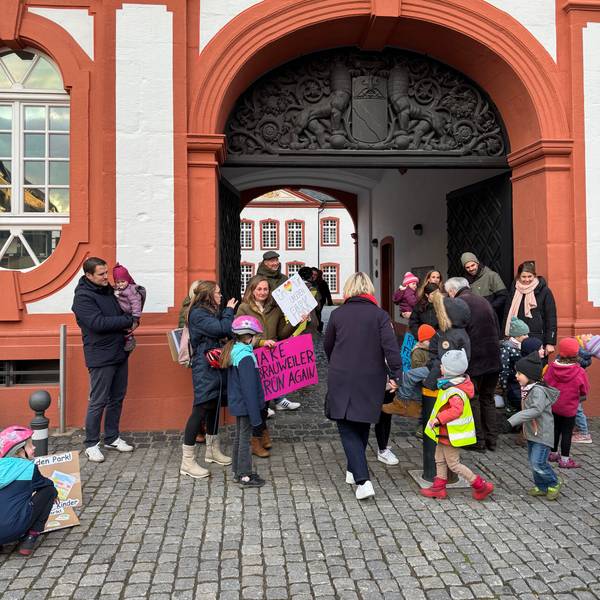 Auf dem Bild sind Eltern und Kinder zu sehen, die für den Erhalt eines Spielplatzes demonstrieren.