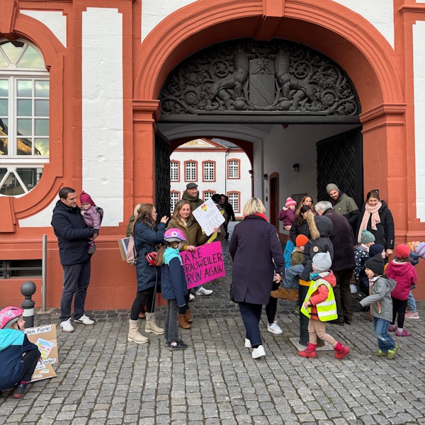 Auf dem Bild sind Eltern und Kinder zu sehen, die für den Erhalt eines Spielplatzes demonstrieren.