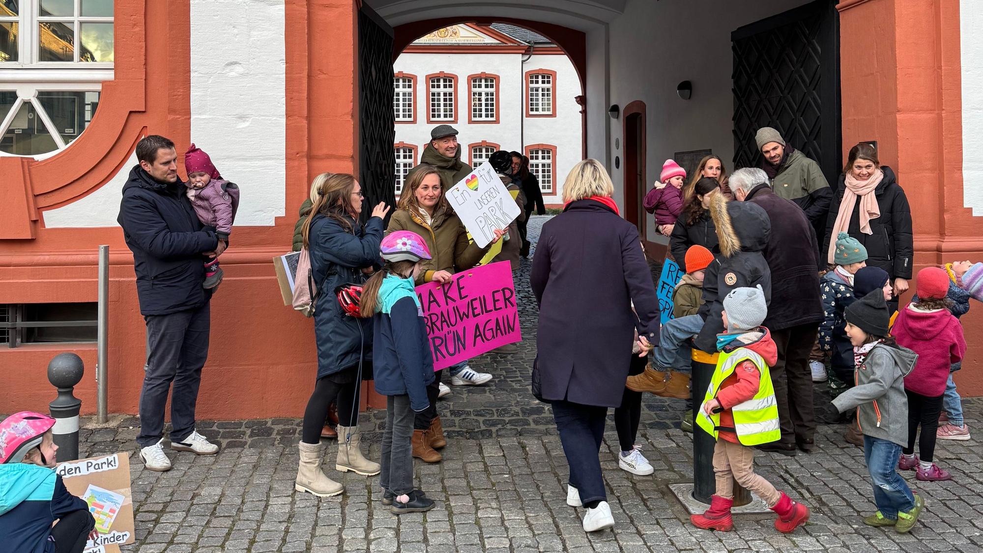 Auf dem Bild sind Eltern und Kinder zu sehen, die für den Erhalt eines Spielplatzes demonstrieren.
