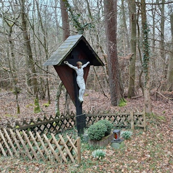 Ein Gedenkkreuz steht im Dollendorfer Busch im Blankenheimer Gemeindewald. Die Bäume haben keine Blätter.