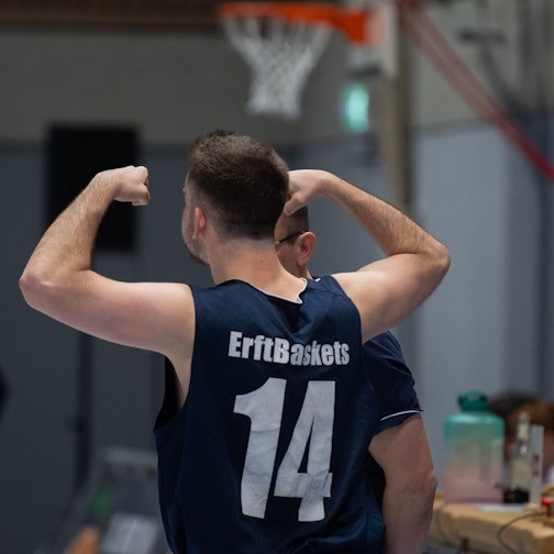 Das Bild zeigt einen Spieler der Erftbaskets, der die kaum vorhandenen Muskeln anspannt.