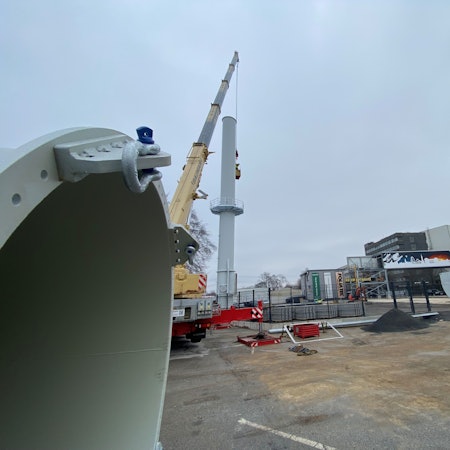 Zu sehen ist ein Schornstein und dahinter das Eisenwerk Brühl.