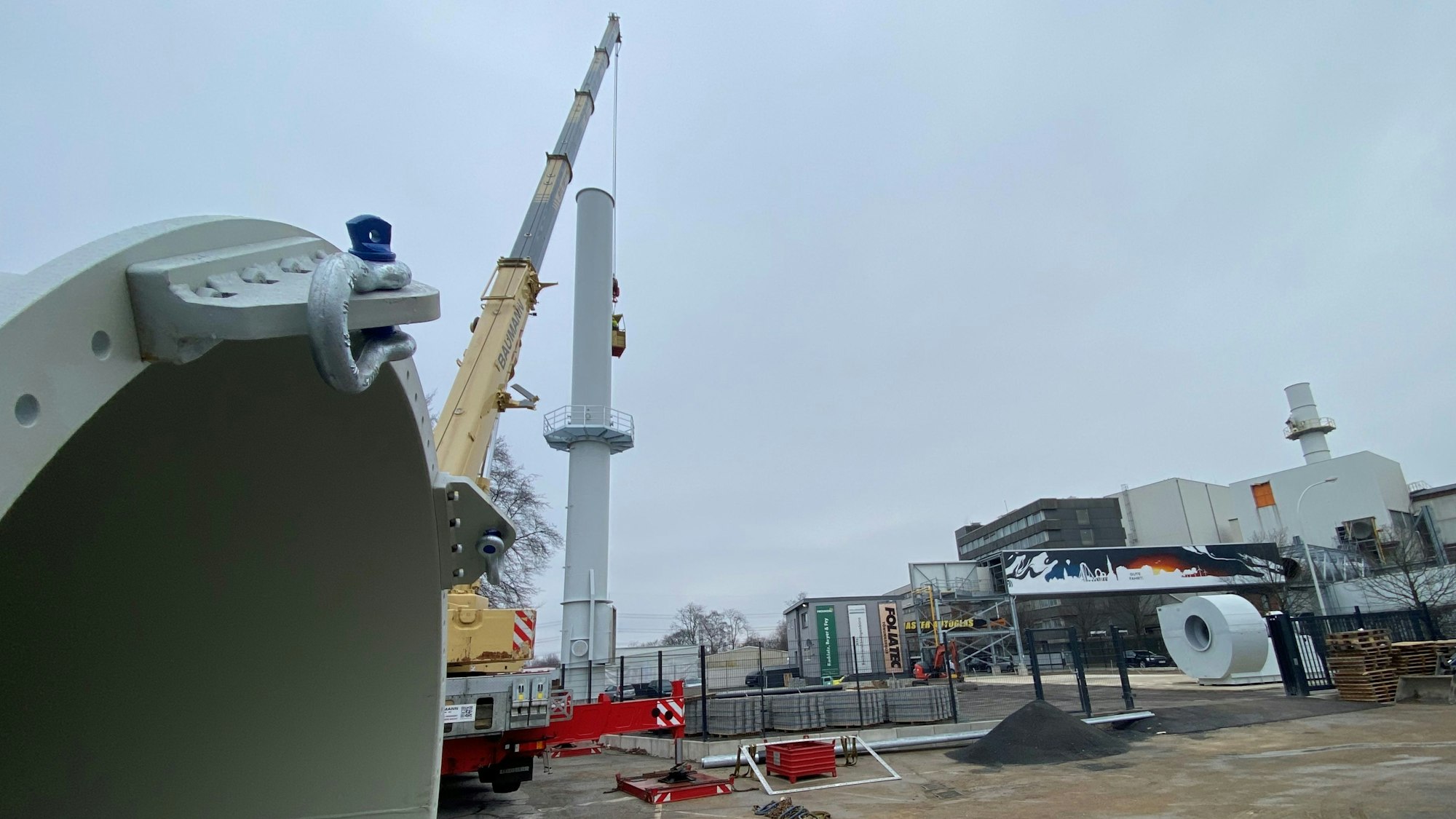 Zu sehen ist ein Schornstein und dahinter das Eisenwerk Brühl.