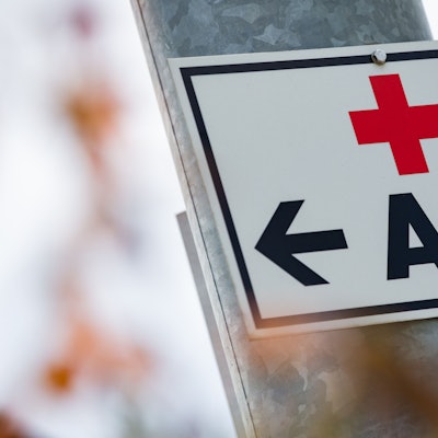 Ein Schild mit der Aufschrift „Arzt“ hängt an einer Straßenlaterne.