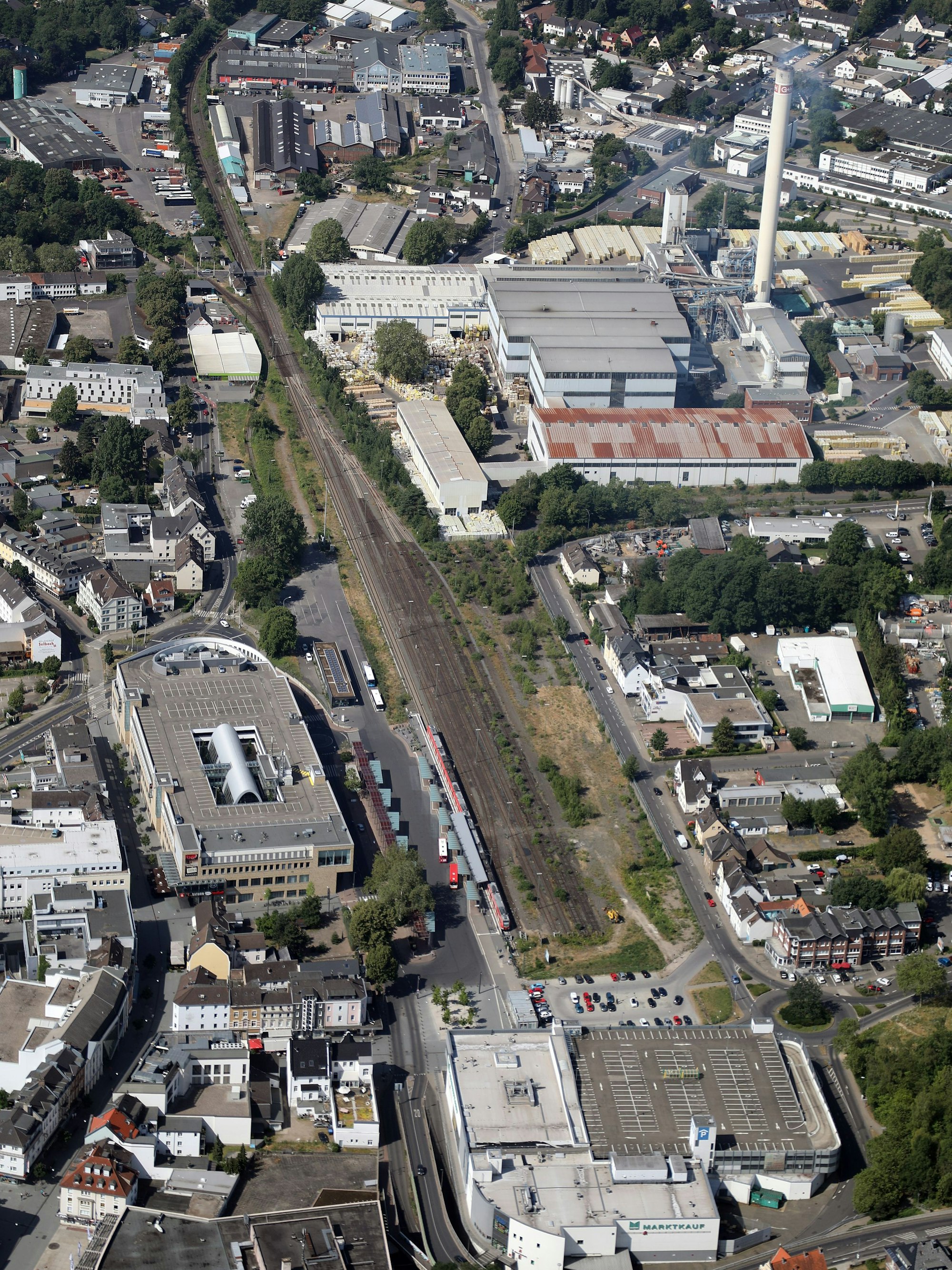 Auf einem Luftbild von Bergisch Gladbach sind zu sehen: S-Bahnhof, Rhein-Berg-Galerie, Rhein-Berg-Passage, G+H Isover, Eisenbahn, Kopfbahnhof, Stadthaus und Driescher Kreisel.