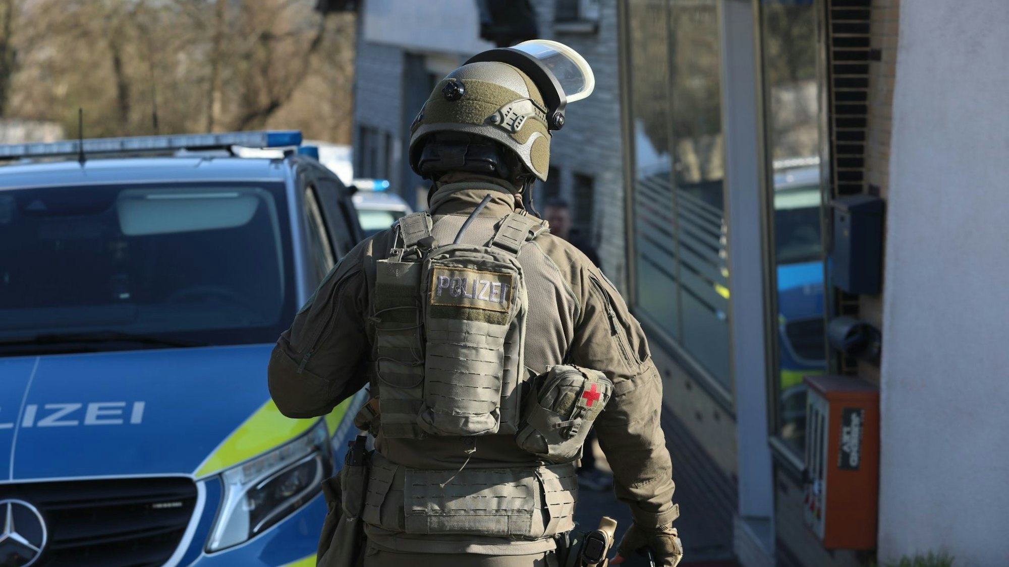 Ein SEK-Beamter neben einem Streifenwagen der Polizei-