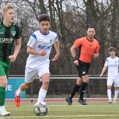 Das Foto zeigt zwei Fußballer im Zweikampf: der Königsdorfer in Weiß läuft seinem Gegenspieler im grün-schwarz gestreiften Dress hinterher.