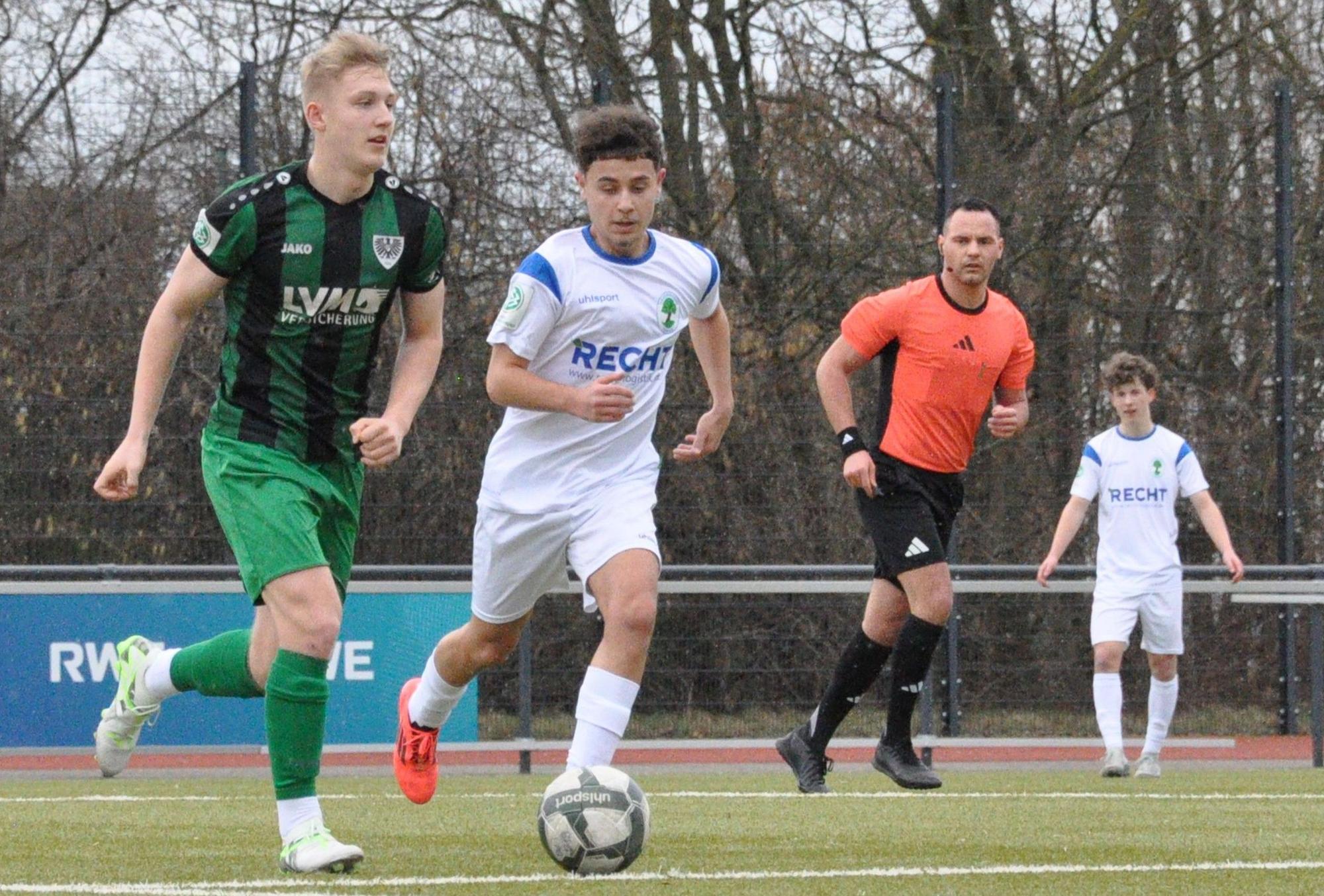 Das Foto zeigt zwei Fußballer im Zweikampf: der Königsdorfer in Weiß läuft seinem Gegenspieler im grün-schwarz gestreiften Dress hinterher.