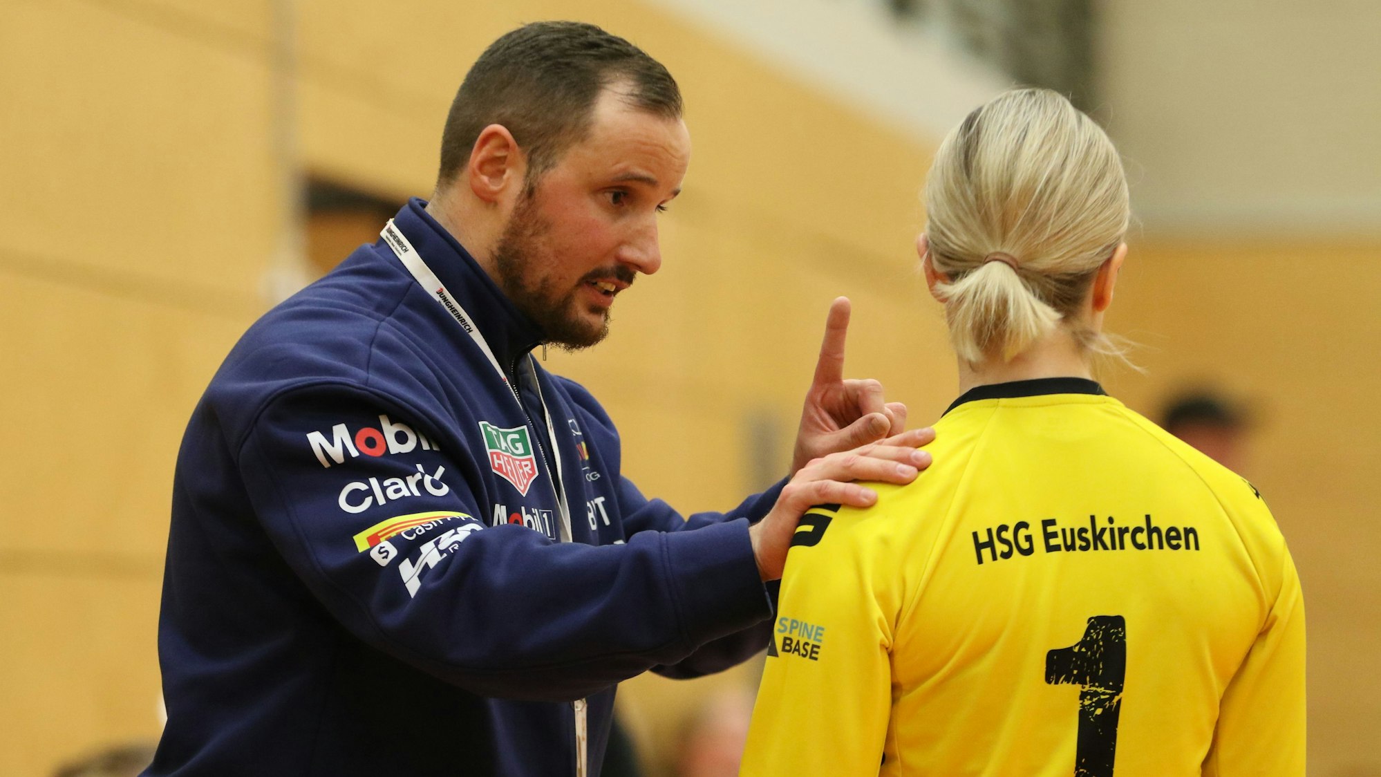 Julian Meyer redet mit erhobenem Zeigefinger und mit Hand auf der Schulter von Torhüterin Barbara Seipel, die nur von hinten zu sehen.