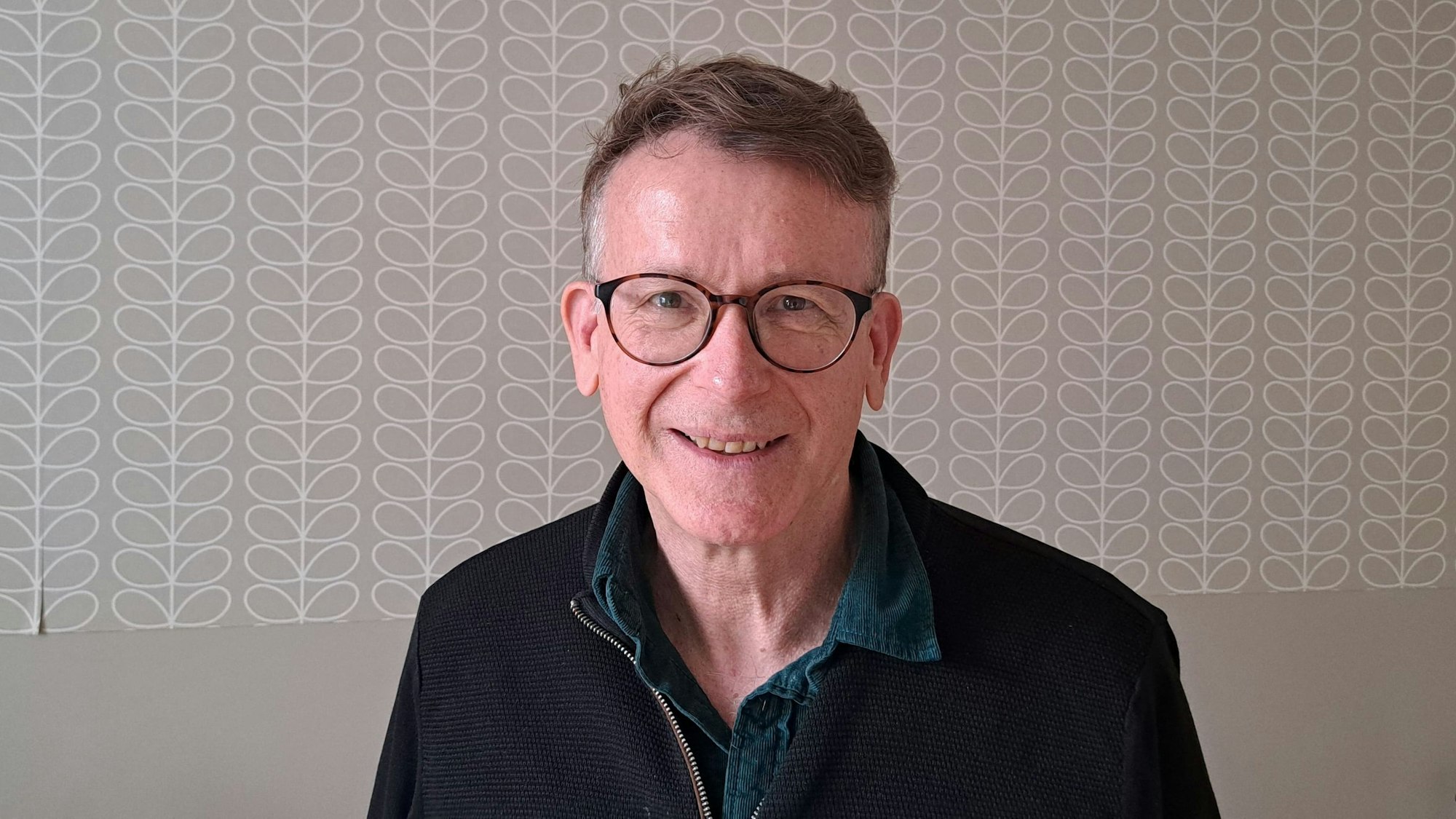 Ein Mann mit Brille lächelt in die Kamera