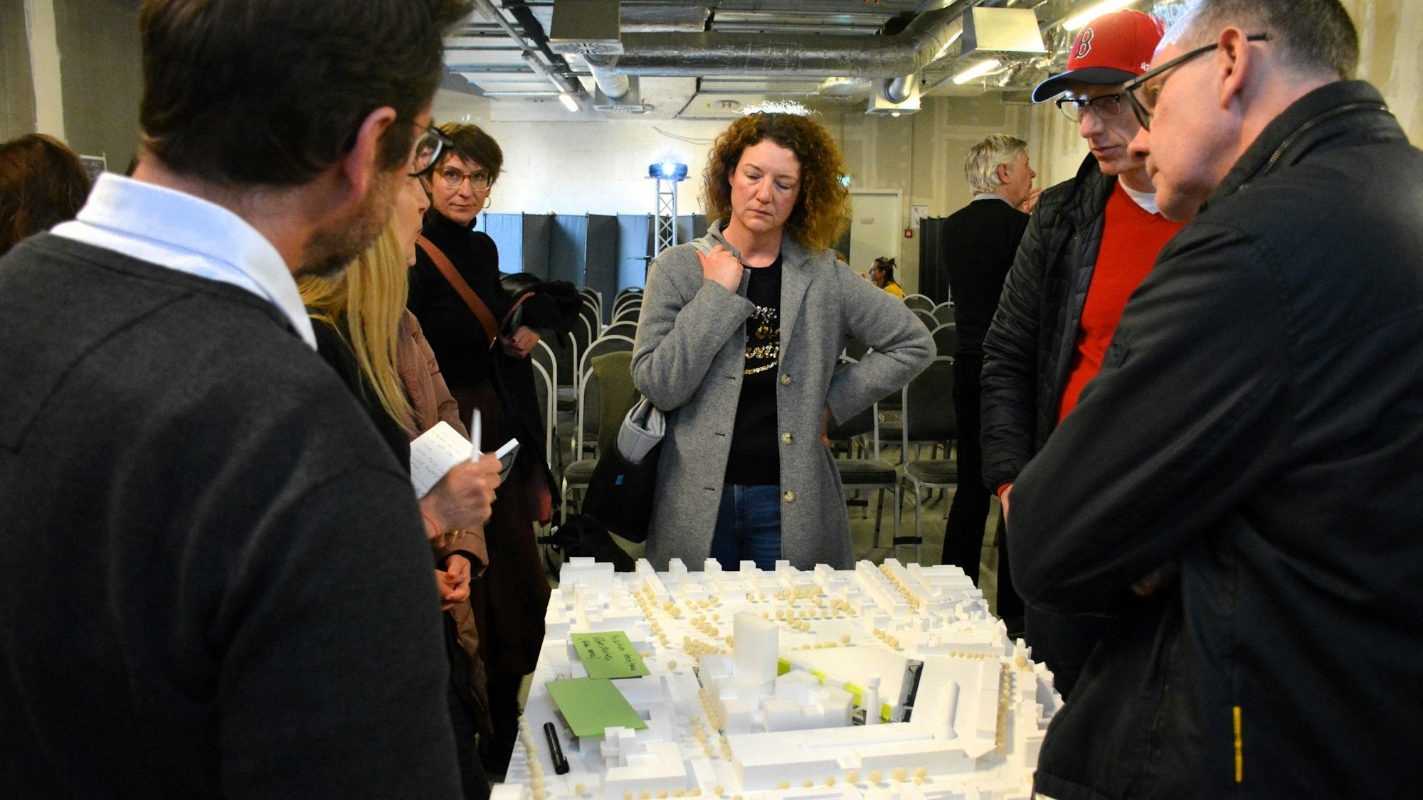 Menschen stehen vor einem Architekturmodell.