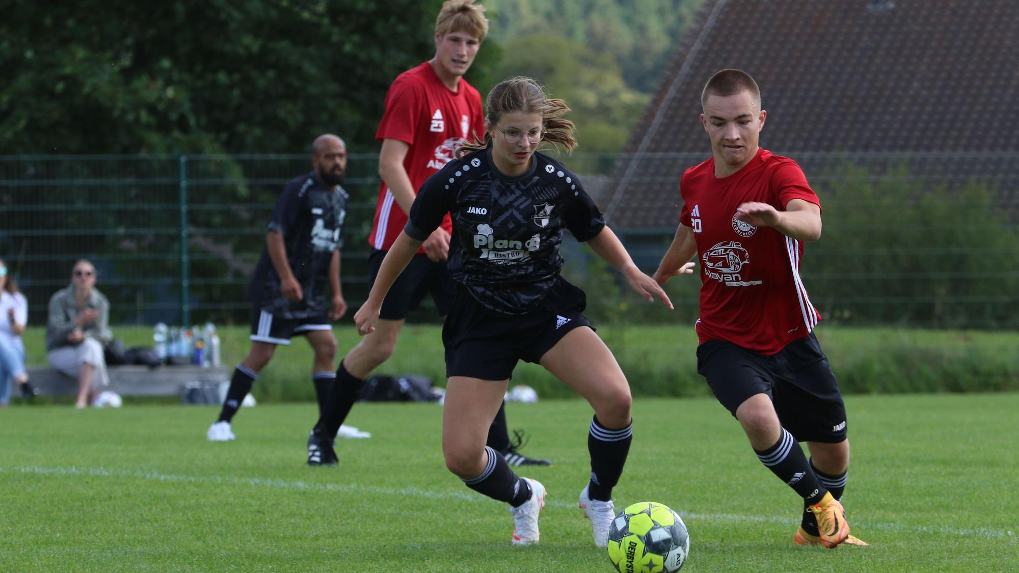 Das Bild zeigt die Spielerin Ophelia Rosenbaum im Zweikampf bei einem Fußballspiel.