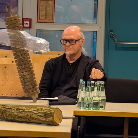 Das Foto zeigt den Künstler, vor sich auf dem Tisch ein Modell des Kunstwerks.