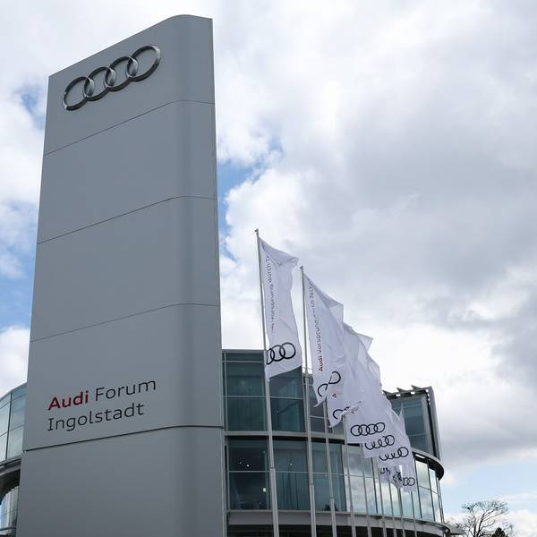 Dunkle Wolken sind hinter Fahnen mit dem Logo von Audi vor dem Audi-Forum zu sehen.