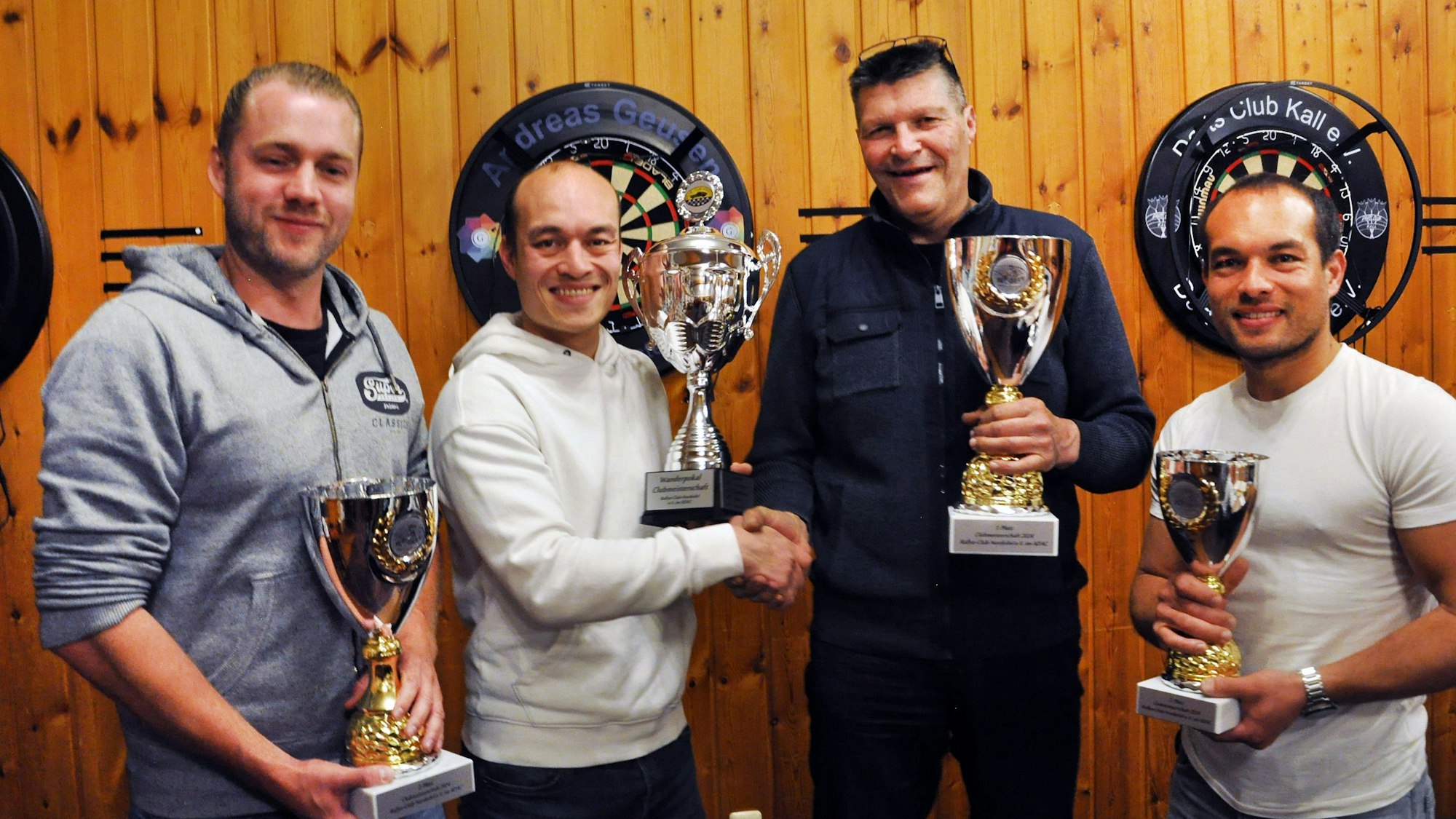 Das Bild zeigt die vier Männer mit Siegerpokalen.