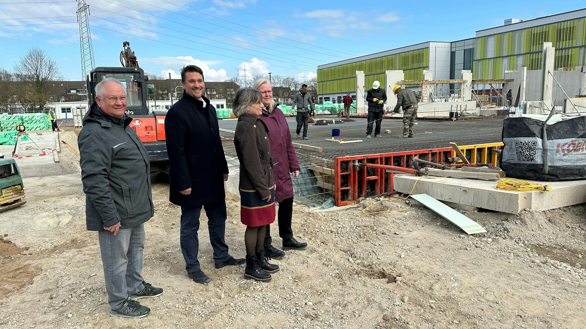 An der Bodenplatte des zweiten Bauabschnitts der Gertrud-Koch-Gesamtschule stehen: Michael Mäder, Projektleiter der Stadt, Bürgermeister Alexander Biber, Schulleiterin Kirsten Heinrichs mit ihrer Stellvertreterin Veronika Diers (v.l.).