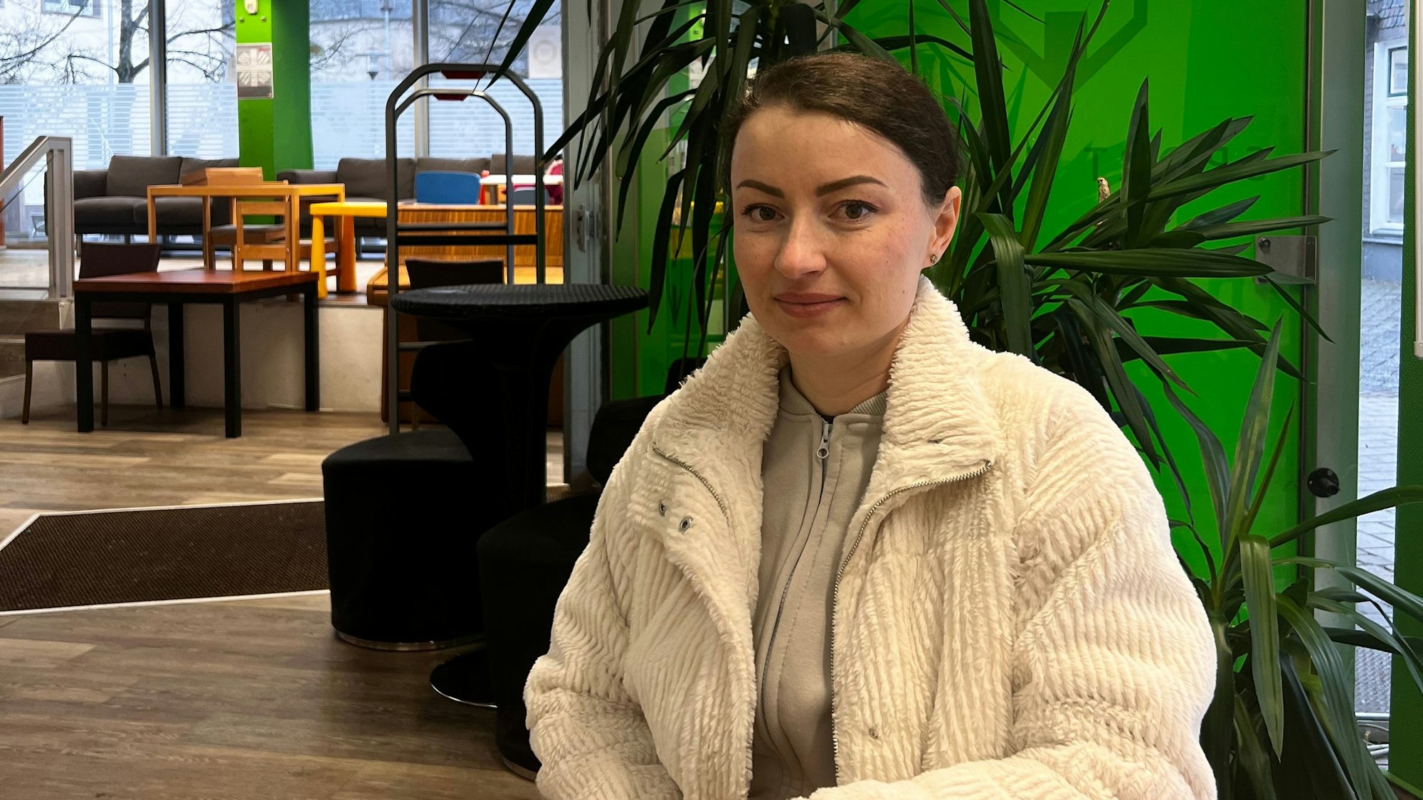 Eine junge Frau sitzt an einem Tisch.