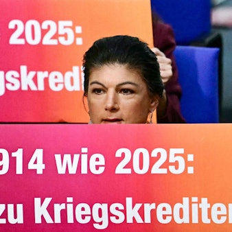 Sahra Wagenknecht hält im Bundestag ein Transparent hoch. Die Aktion brachte dem BSW einen Ordnungsruf ein.