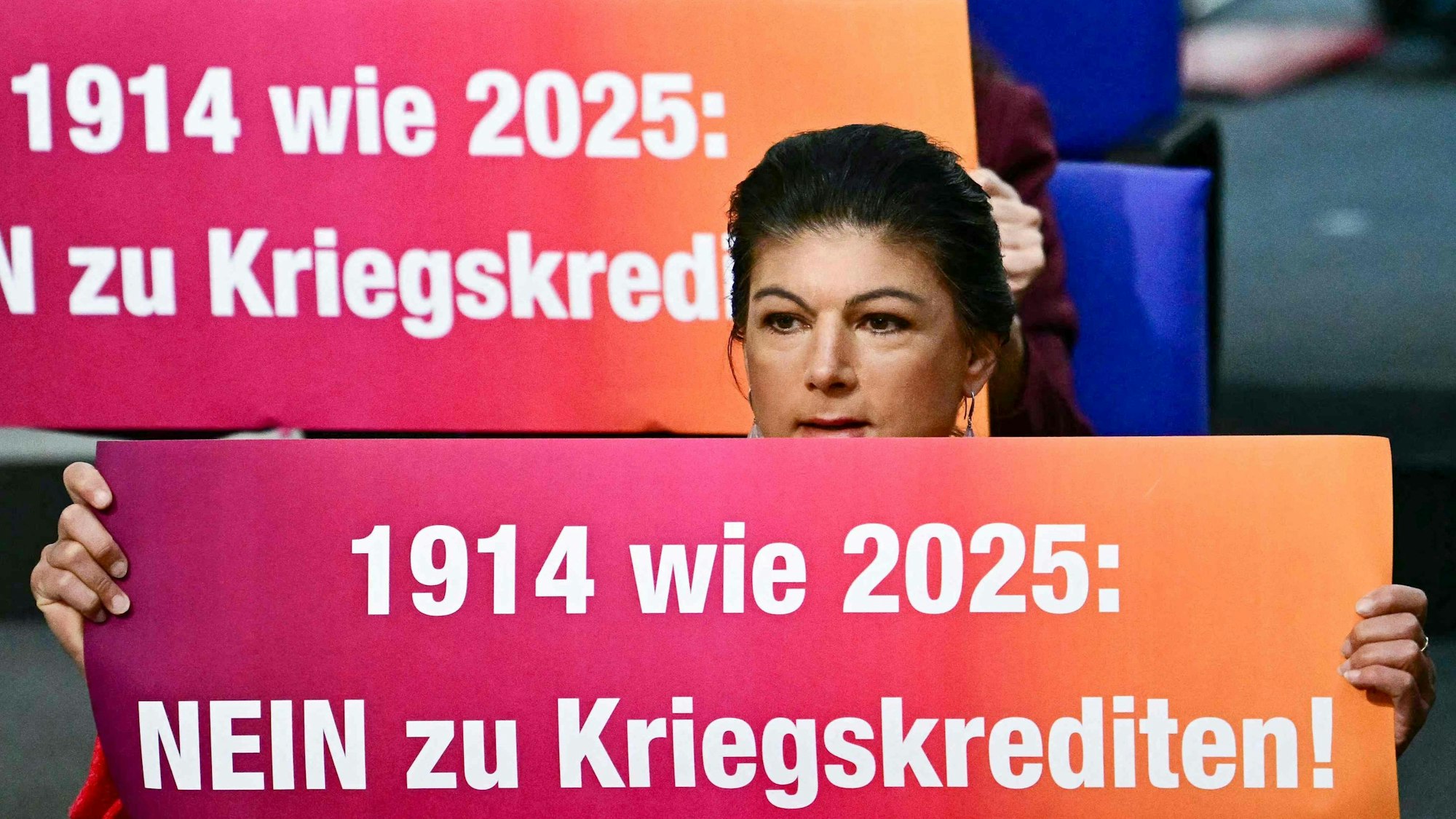 Sahra Wagenknecht hält im Bundestag ein Transparent hoch. Die Aktion brachte dem BSW einen Ordnungsruf ein.