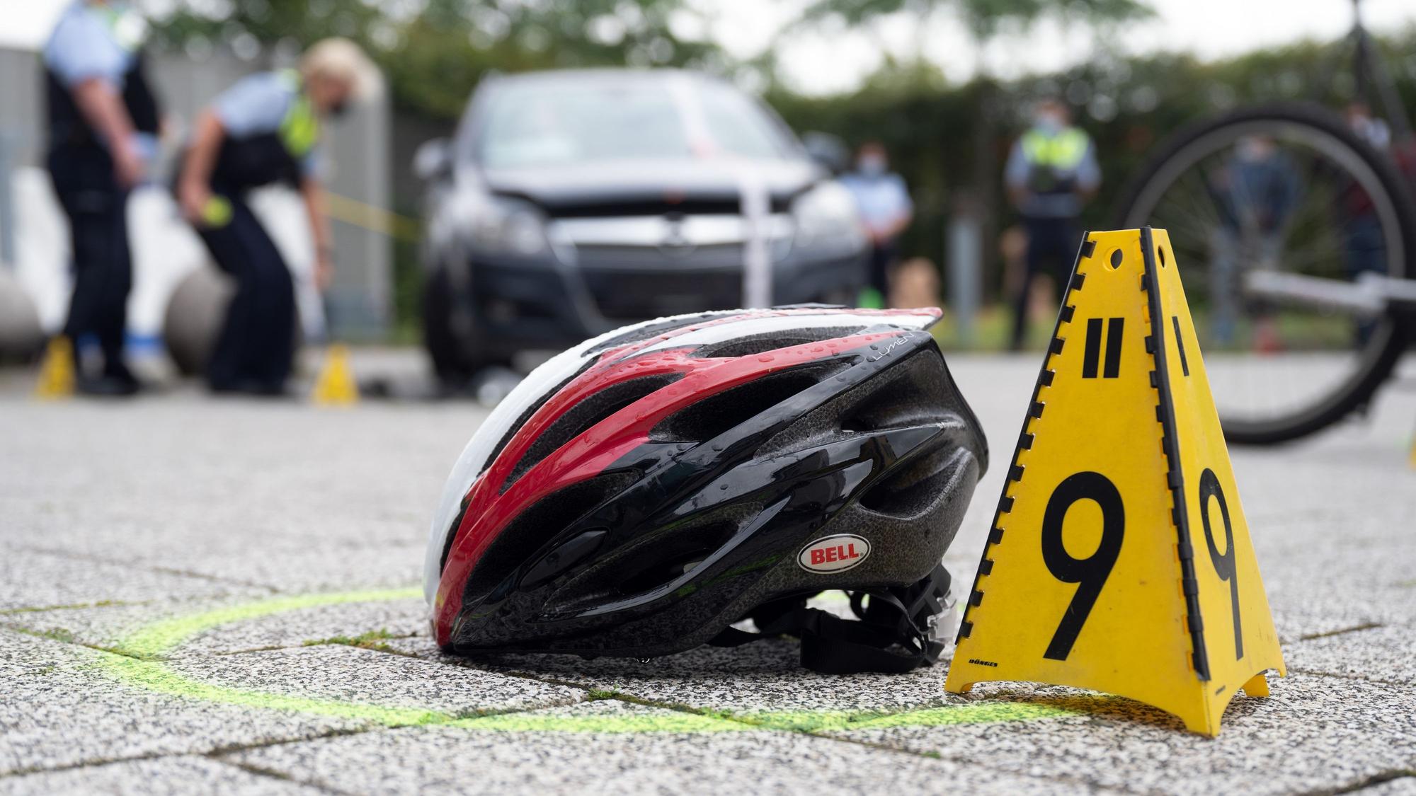 Ein Fahrradhelm liegt bei einer Verkehrsunfallaufnahme auf dem Boden.