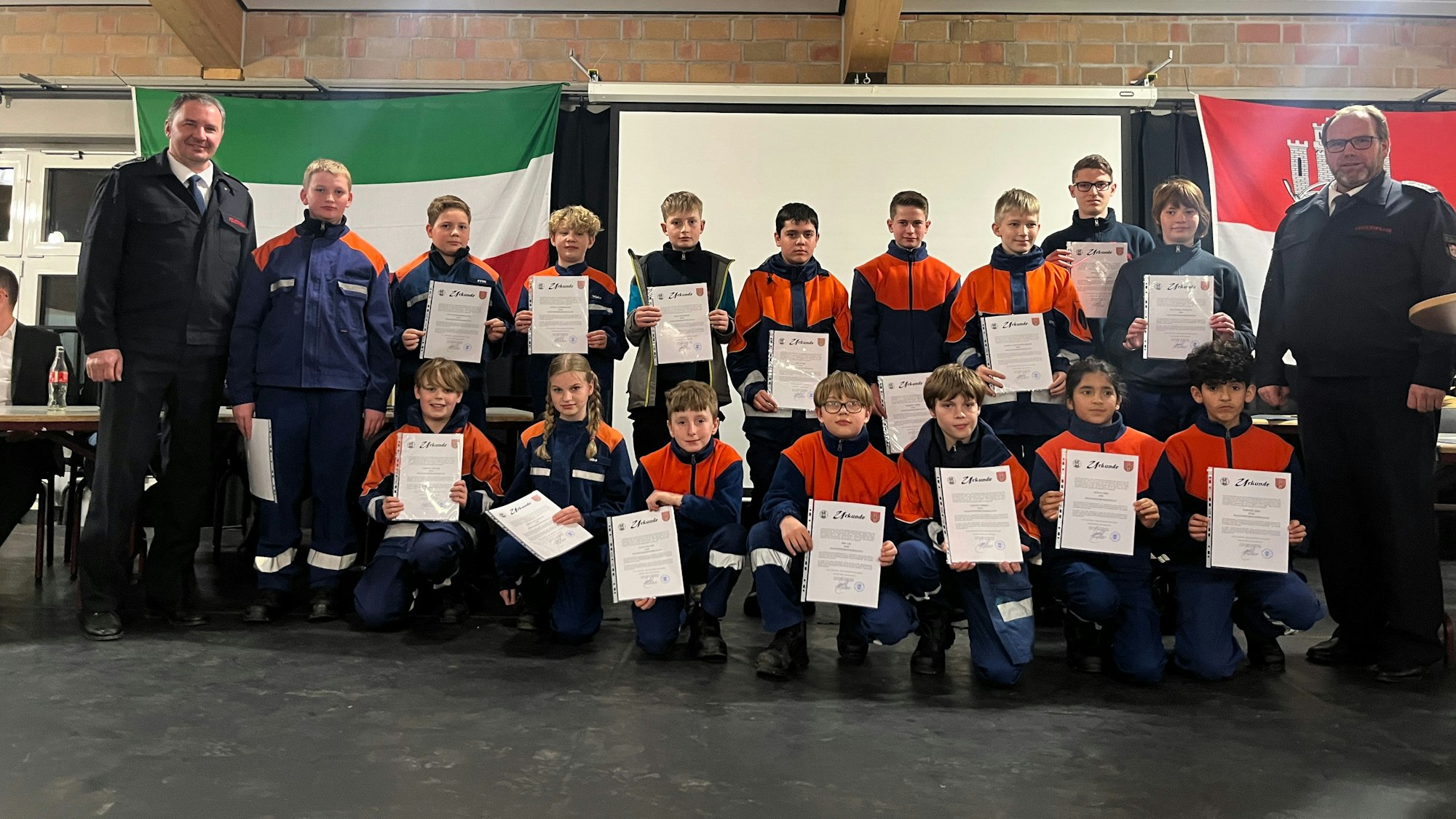 Die Feuerwehr Hennef hielt ihre Jahreshauptversammlung in der Mensa der Gesamtschule Meiersheide ab. Auf der Bühne wurden Jugen und Mädchen zu Jugendfeuerwehrmännern und -frauen befördert.