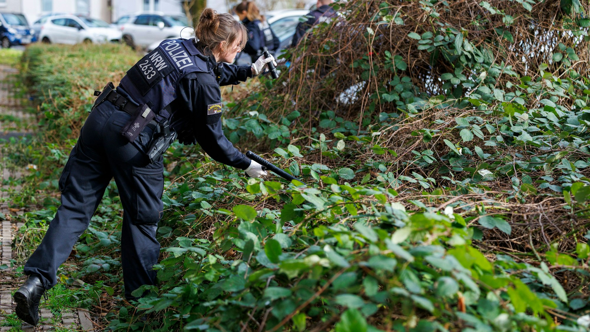 Polizisten suchen nach Spuren im Umfeld eines Tatorts.