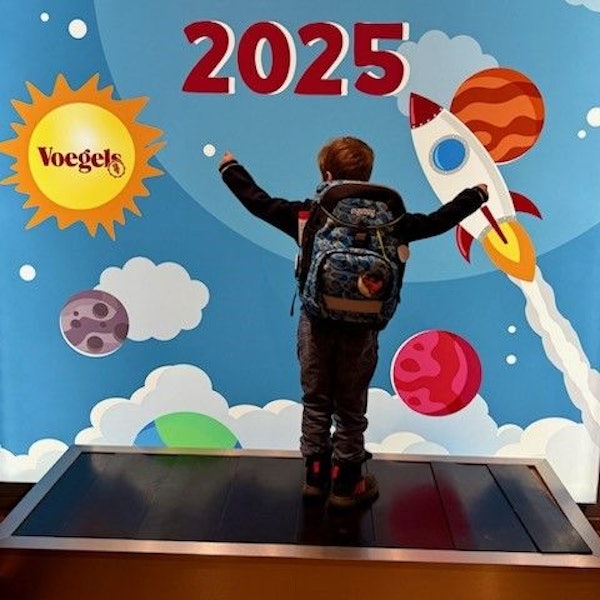 Der neue Ranzen wird vor der Fotowand demonstriert