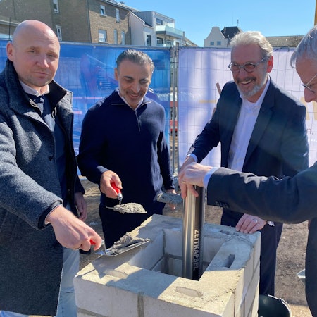 Zu sehen sind die Vertreter von Bauunternehmen und der Bürgermeister bei der Grundsteinlegung.