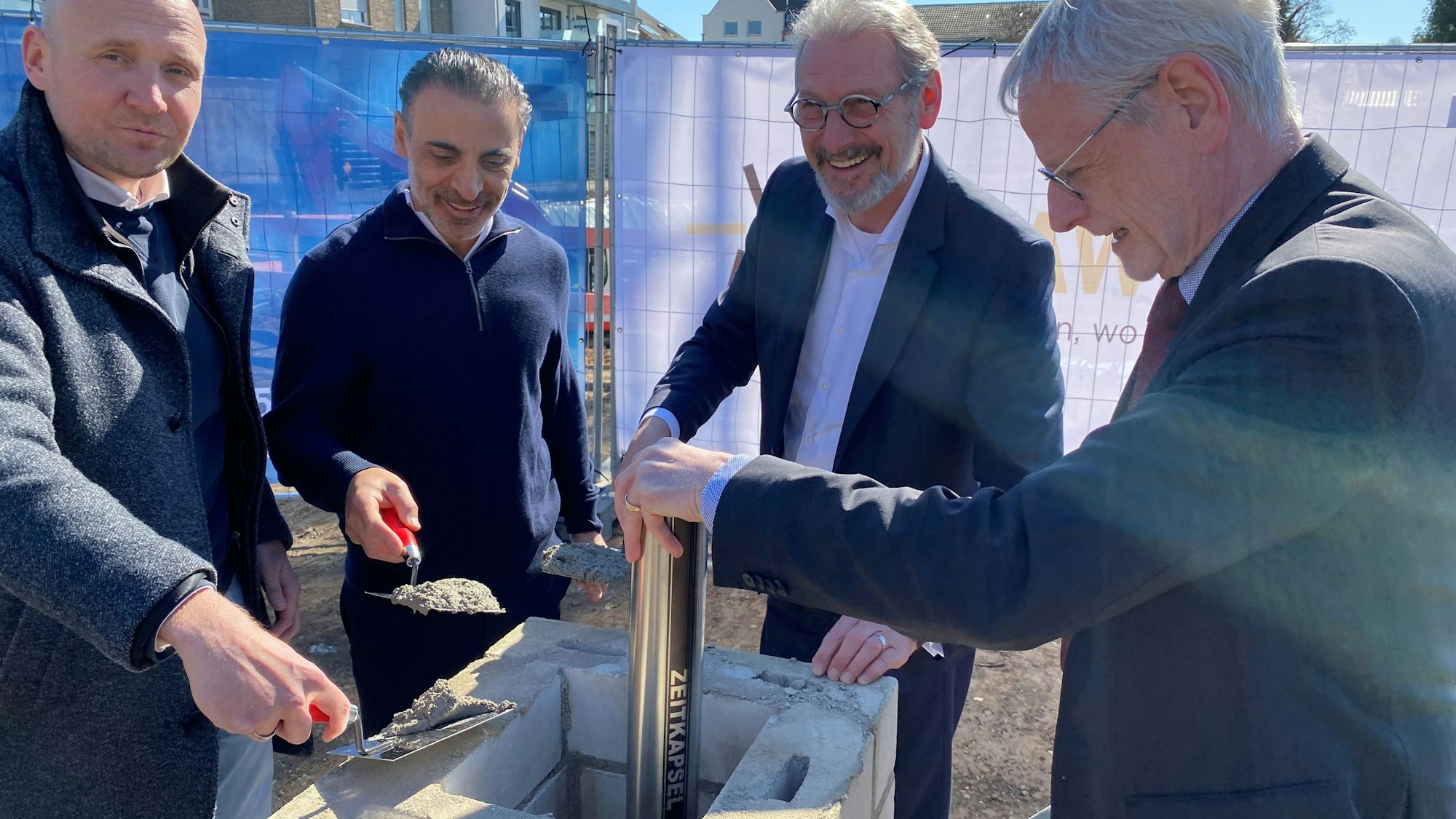 Zu sehen sind die Vertreter von Bauunternehmen und der Bürgermeister bei der Grundsteinlegung.